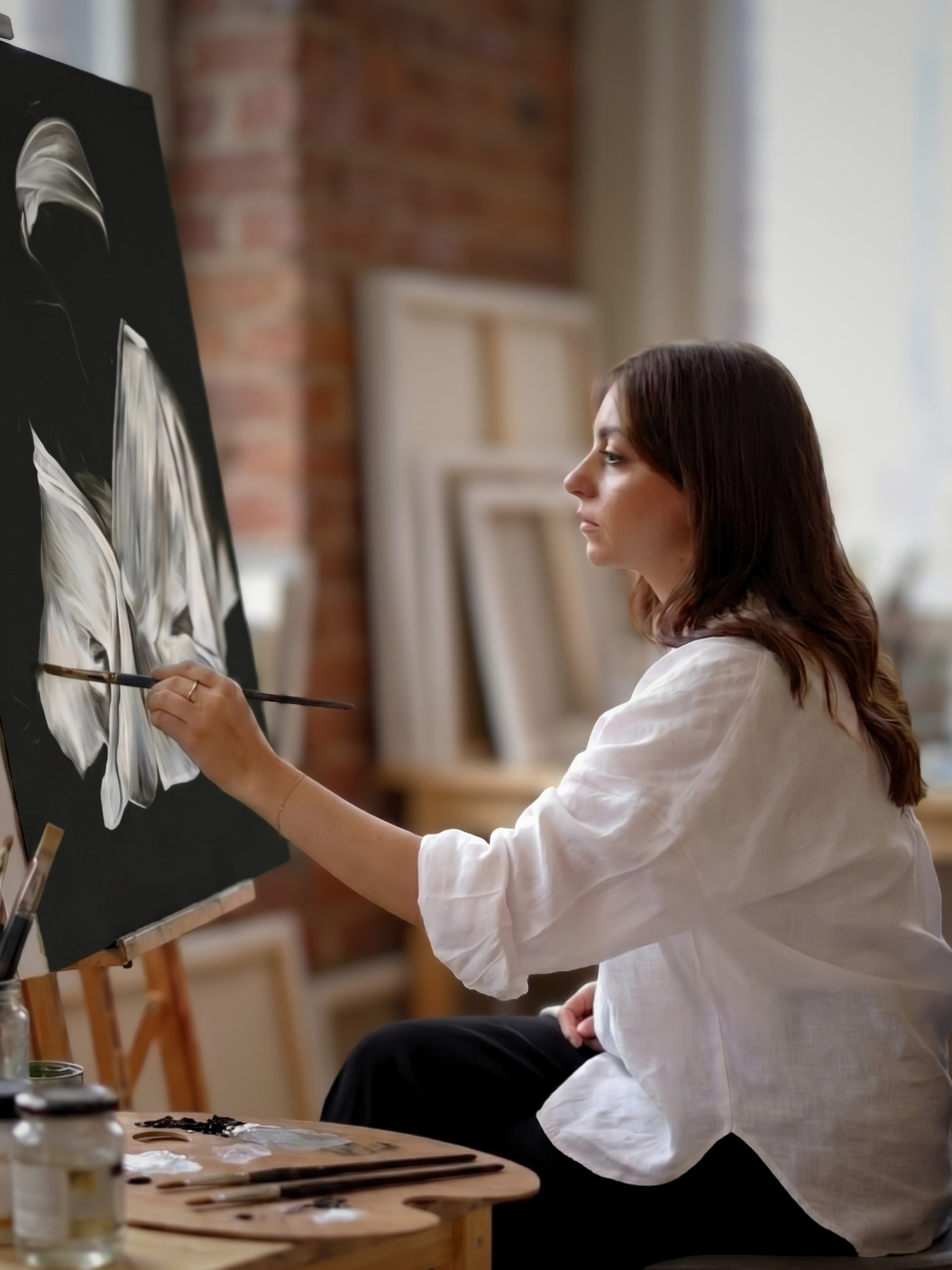 Annem Zaidi painting at her easel — Bethesda atelier interior